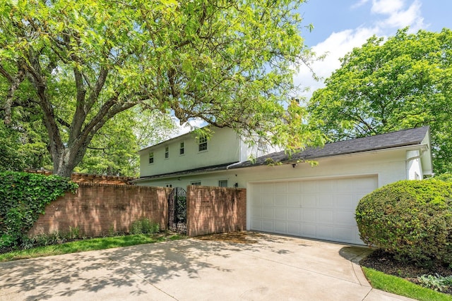 4465 Loos Cir E, Columbus, OH 43214 - view of side of home with concrete driveway, a garage, and brick siding