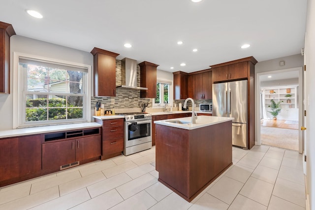 4465 Loos Cir E, Columbus, OH 43214 - kitchen with appliances with stainless steel finishes, wall chimney range hood, light countertops, decorative backsplash, and a center island with sink