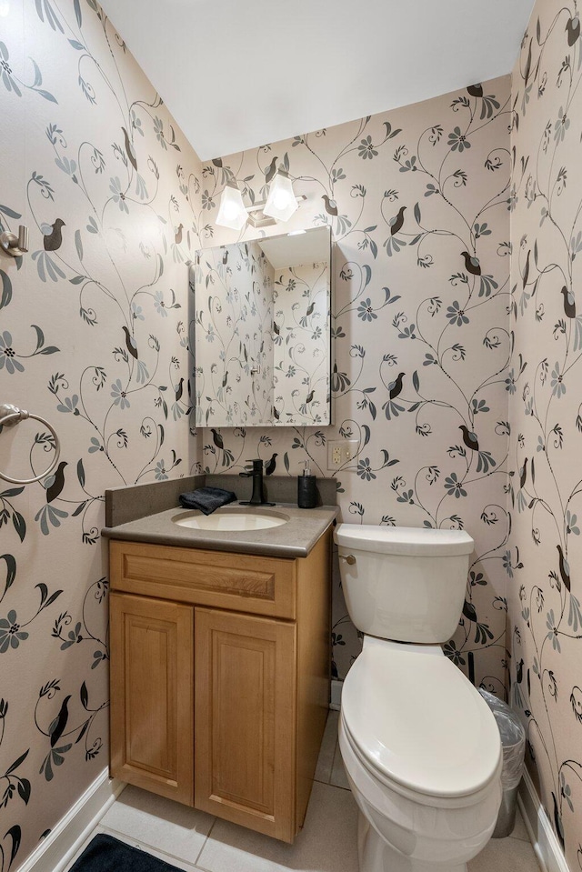 4465 Loos Cir E, Columbus, OH 43214 - bathroom featuring wallpapered walls, vanity, toilet, tile patterned floors, and baseboards