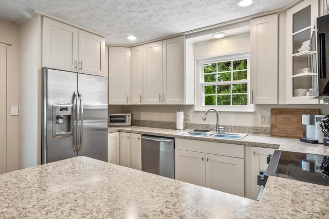 590 Haversham Dr, Gahanna, OH 43230 - kitchen with stainless steel appliances, light countertops, glass insert cabinets, a textured ceiling, and recessed lighting