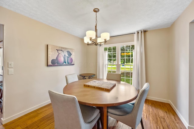 590 Haversham Dr, Gahanna, OH 43230 - dining room with a chandelier, light wood-style floors, and a textured ceiling