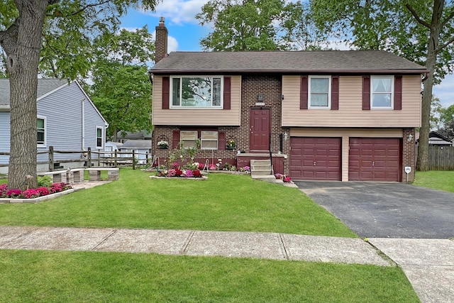 6024 Winterberry Dr, Galloway, OH 43119 - raised ranch with a garage, asphalt driveway, a chimney, and brick siding