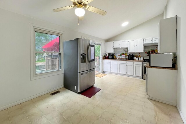6024 Winterberry Dr, Galloway, OH 43119 - kitchen featuring stainless steel appliances, a sink, vaulted ceiling, dark countertops, and white cabinets