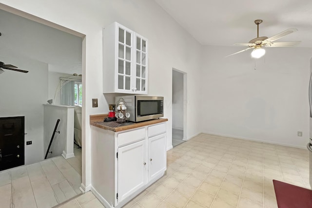 6024 Winterberry Dr, Galloway, OH 43119 - kitchen with stainless steel microwave, ceiling fan, glass insert cabinets, white cabinets, and wooden counters