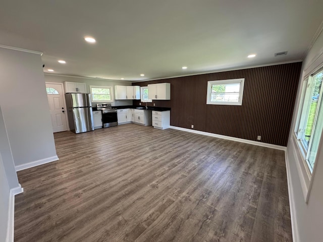 2075 Rankin Ave, Columbus, OH 43219 - unfurnished living room with crown molding, plenty of natural light, dark wood-type flooring, baseboards, and recessed lighting