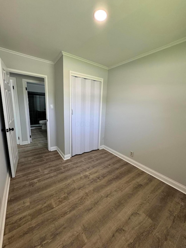 2075 Rankin Ave, Columbus, OH 43219 - unfurnished bedroom with baseboards, a closet, crown molding, and dark wood-type flooring