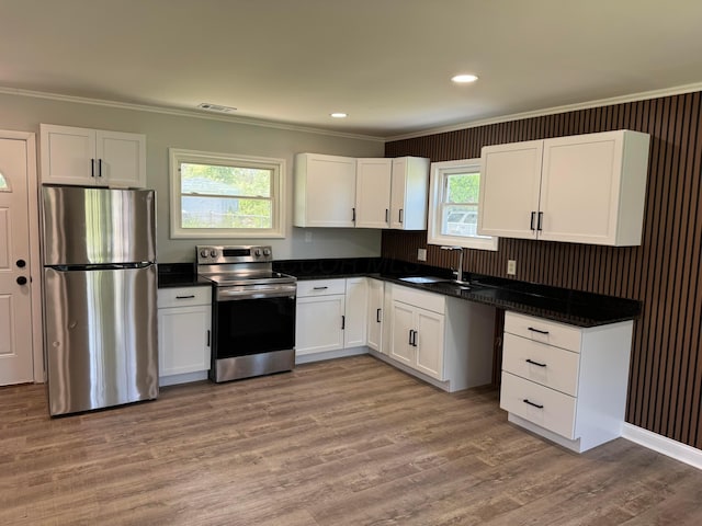 2075 Rankin Ave, Columbus, OH 43219 - kitchen with appliances with stainless steel finishes, ornamental molding, dark countertops, white cabinets, and recessed lighting
