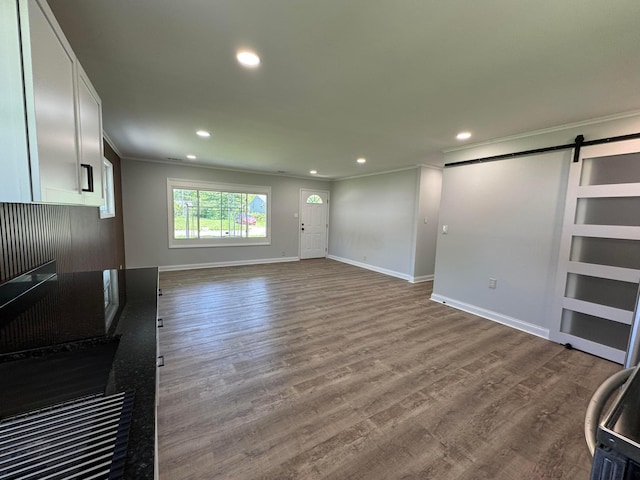 2075 Rankin Ave, Columbus, OH 43219 - unfurnished living room with crown molding, a barn door, recessed lighting, baseboards, and wood finished floors