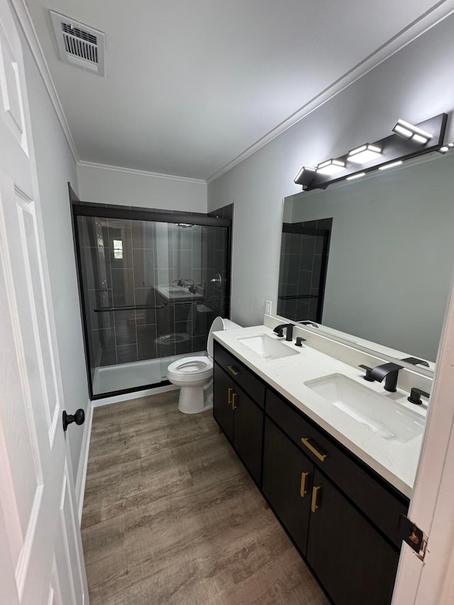2075 Rankin Ave, Columbus, OH 43219 - bathroom featuring double vanity, a shower stall, toilet, wood finished floors, and crown molding