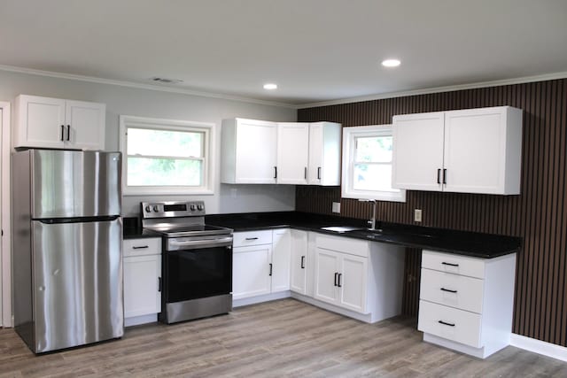 2075 Rankin Ave, Columbus, OH 43219 - kitchen with appliances with stainless steel finishes, ornamental molding, dark countertops, white cabinetry, and a sink