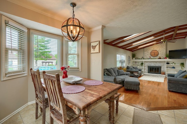 12179 Woodrow Ln, Pickerington, OH 43147 - dining room featuring a chandelier, light tile patterned flooring, ceiling fan, a fireplace, and a textured ceiling