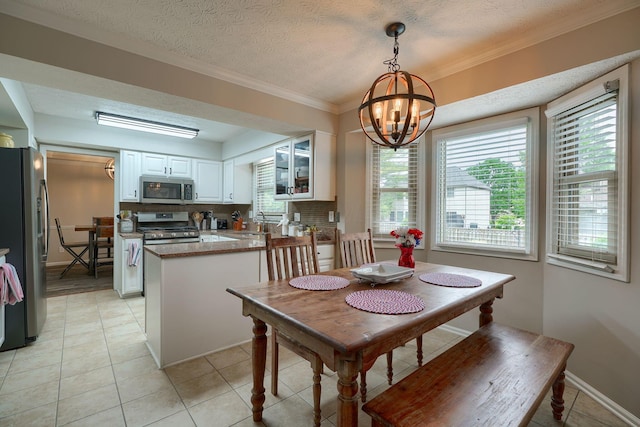 12179 Woodrow Ln, Pickerington, OH 43147 - dining area with a chandelier, light tile patterned flooring, ornamental molding, baseboards, and a textured ceiling