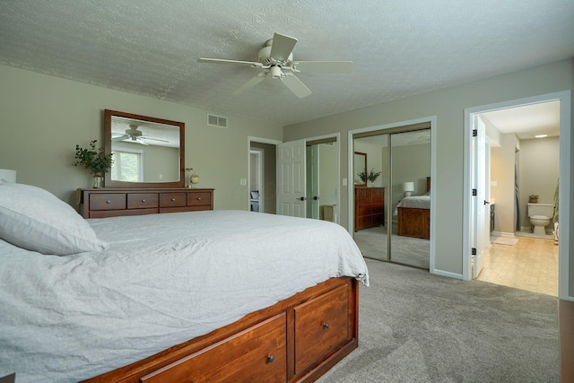 12179 Woodrow Ln, Pickerington, OH 43147 - bedroom featuring light colored carpet, two closets, ceiling fan, ensuite bath, and a textured ceiling