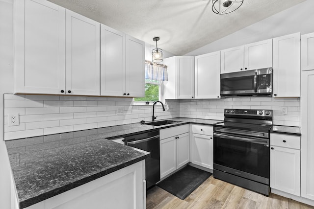7263 Saddletree Ct, Reynoldsburg, OH 43068 - kitchen with stainless steel appliances, a sink, lofted ceiling, white cabinets, and a textured ceiling
