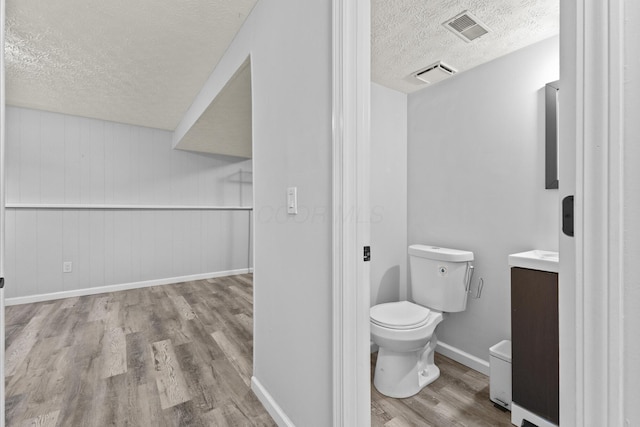 7263 Saddletree Ct, Reynoldsburg, OH 43068 - bathroom with a textured ceiling, wood finished floors, toilet, vanity, and baseboards