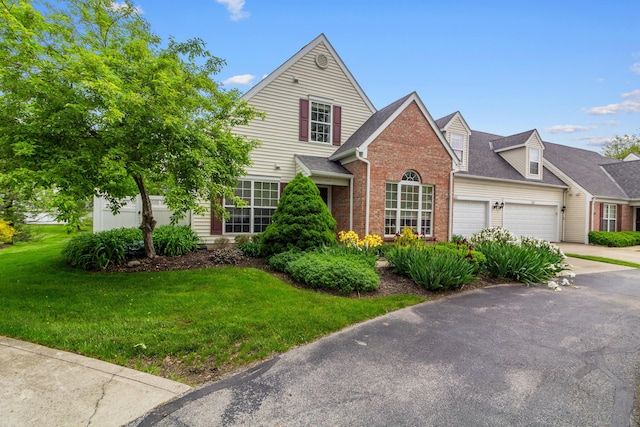 8699 Lazelle Commons Dr, Lewis Center, OH 43035 - view of front of property with a front lawn, a garage, brick siding, driveway, and roof with shingles