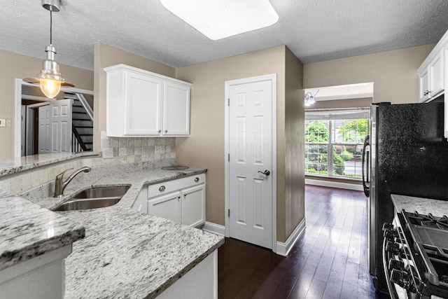 8699 Lazelle Commons Dr, Lewis Center, OH 43035 - kitchen with a sink, stainless steel range with gas cooktop, light stone counters, white cabinetry, and a textured ceiling