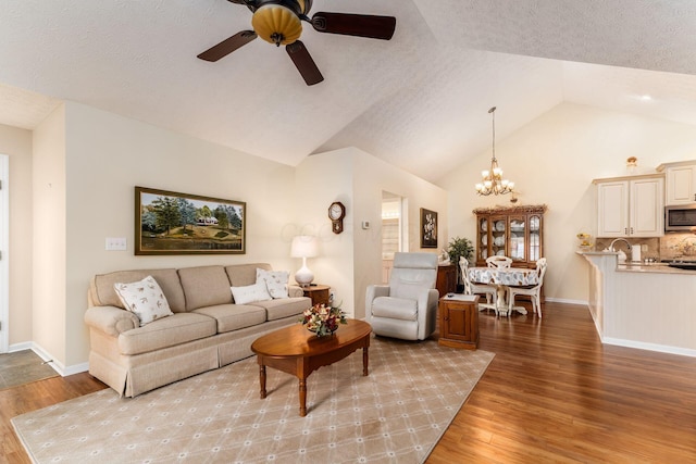 6681 Lakeview Cir, Canal Winchester, OH 43110 - living area with ceiling fan, vaulted ceiling, a chandelier, light wood-style floors, and baseboards