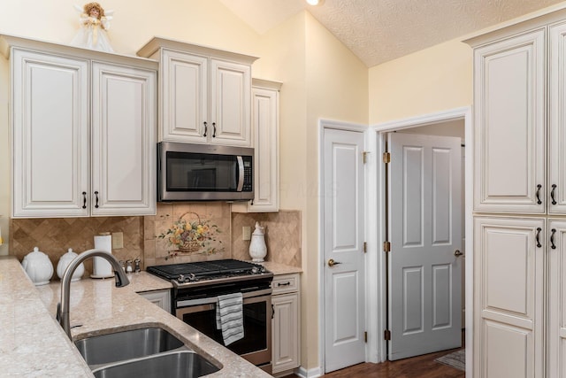 6681 Lakeview Cir, Canal Winchester, OH 43110 - kitchen with appliances with stainless steel finishes, a sink, decorative backsplash, light stone counters, and lofted ceiling