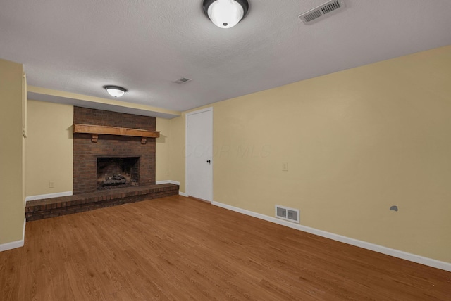 198 Loveman Ave, Worthington, OH 43085 - unfurnished living room featuring baseboards, wood finished floors, a fireplace, and a textured ceiling