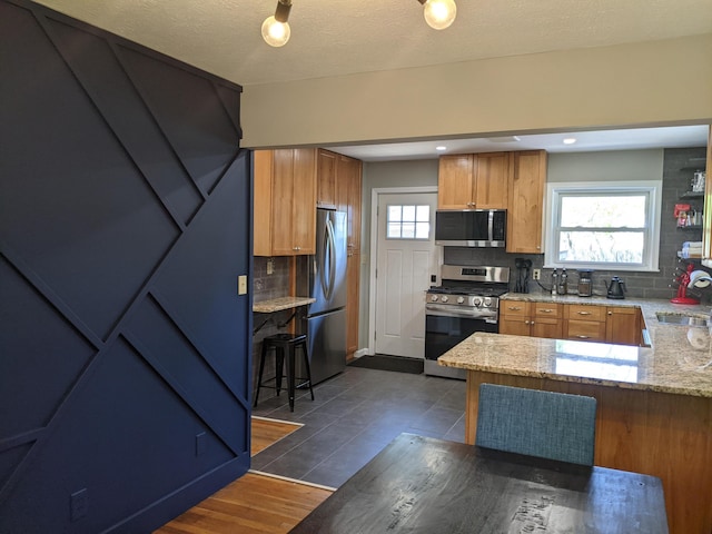 198 Loveman Ave, Worthington, OH 43085 - kitchen with stainless steel appliances, a sink, decorative backsplash, and plenty of natural light
