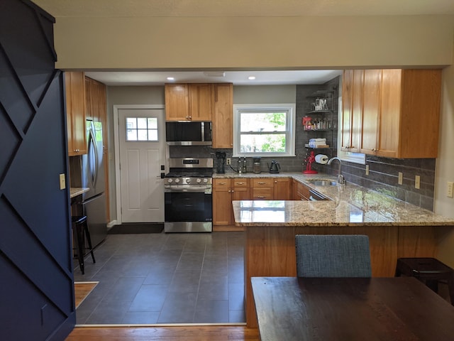 198 Loveman Ave, Worthington, OH 43085 - kitchen featuring appliances with stainless steel finishes, a peninsula, a sink, decorative backsplash, and healthy amount of natural light