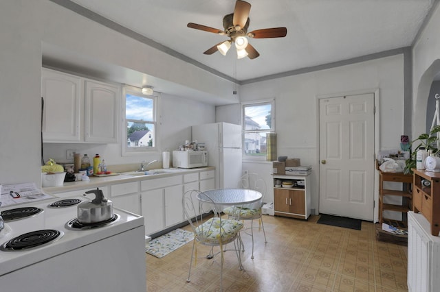 936 Washington Ave, Lancaster, OH 43130 - kitchen featuring white appliances, ceiling fan, white cabinets, light countertops, and healthy amount of natural light