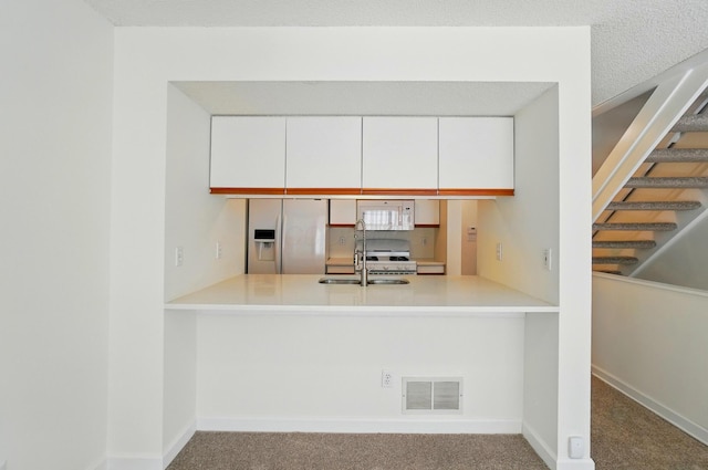 2511 Gardenia Dr Unit 76A, Columbus, OH 43235 - kitchen with white appliances, a sink, a peninsula, and carpet