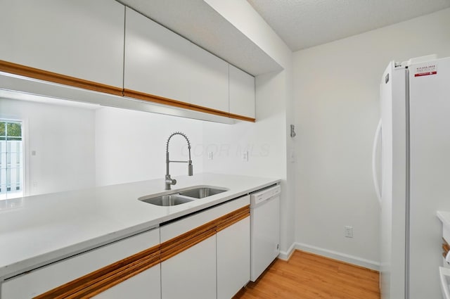 2511 Gardenia Dr Unit 76A, Columbus, OH 43235 - kitchen with white appliances, a sink, light wood-type flooring, white cabinetry, and light countertops