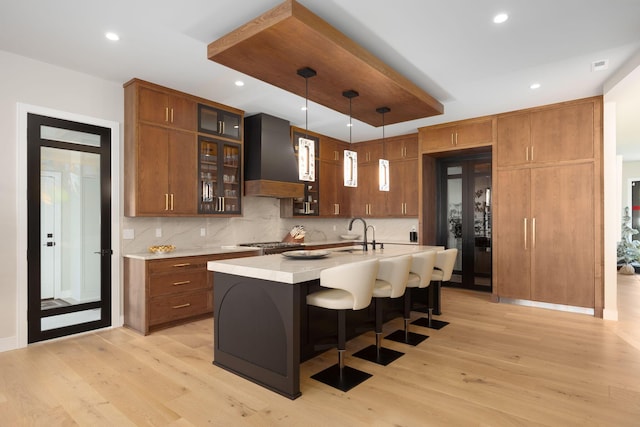 8159 Riverside Dr, Powell, OH 43065 - kitchen featuring custom exhaust hood, light wood-style floors, light countertops, decorative backsplash, and recessed lighting