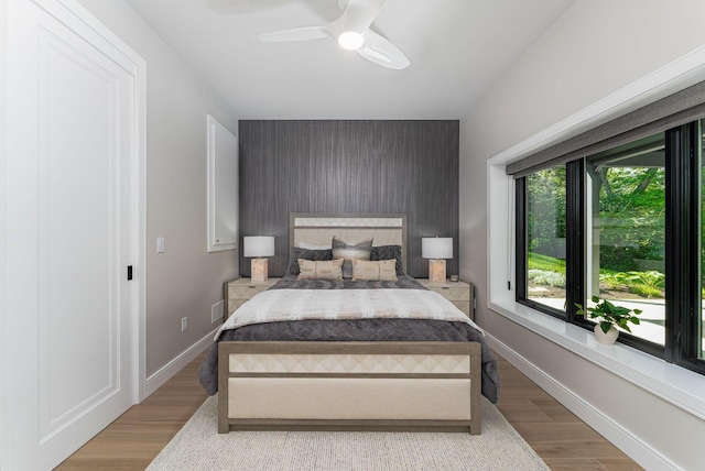 8159 Riverside Dr, Powell, OH 43065 - bedroom featuring an accent wall, wood finished floors, ceiling fan, and baseboards