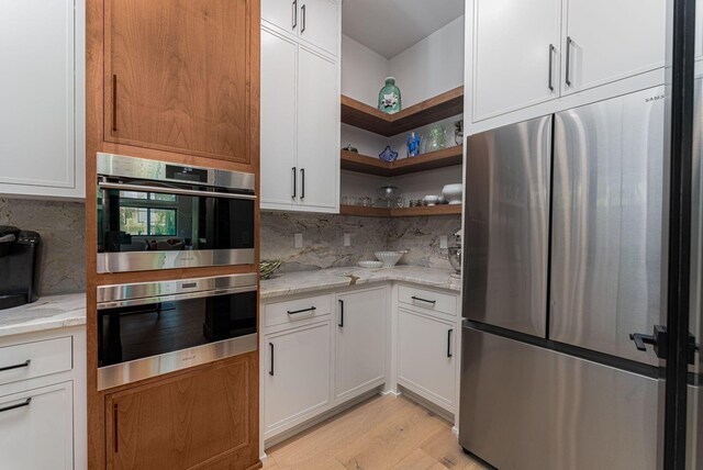 8159 Riverside Dr, Powell, OH 43065 - kitchen with appliances with stainless steel finishes, open shelves, light stone counters, white cabinets, and tasteful backsplash
