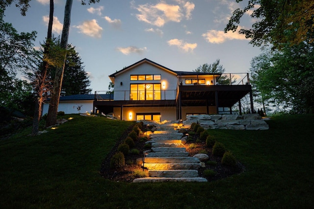 8159 Riverside Dr, Powell, OH 43065 - back of house at dusk with a yard, a wooden deck, and stucco siding
