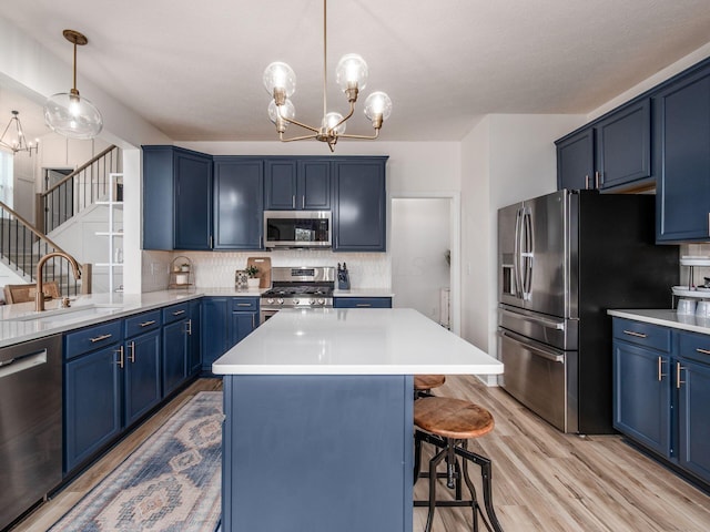 593 Summer Tree Loop, Marysville, OH 43040 - kitchen with appliances with stainless steel finishes, blue cabinetry, a sink, and a chandelier