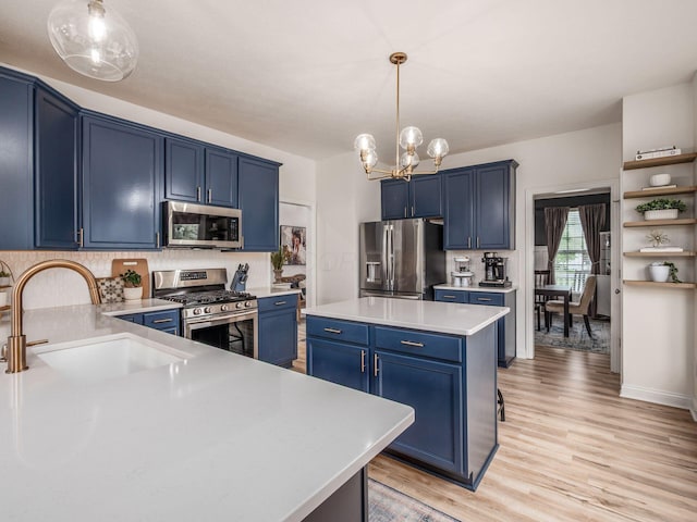 593 Summer Tree Loop, Marysville, OH 43040 - kitchen featuring stainless steel appliances, blue cabinets, a sink, light countertops, and a chandelier