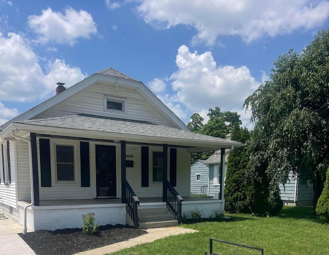 4469 Lancaster Ave, Columbus, OH 43207 - view of front facade with a porch, a shingled roof, a front lawn, and a chimney