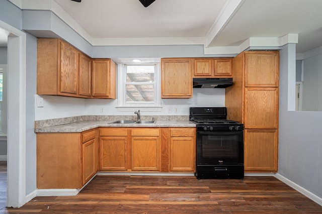 4469 Lancaster Ave, Columbus, OH 43207 - kitchen with black gas range, under cabinet range hood, dark wood-style flooring, light countertops, and decorative backsplash