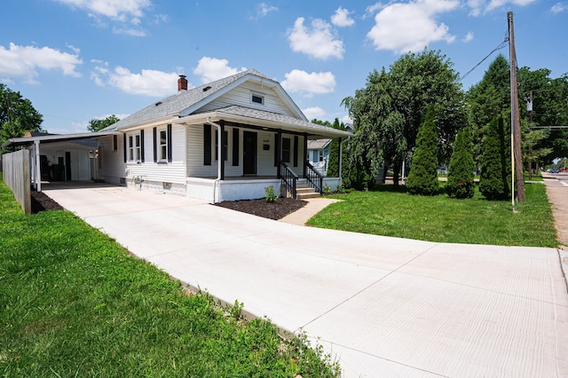 4469 Lancaster Ave, Columbus, OH 43207 - rear view of house with covered porch, driveway, an attached carport, a chimney, and a yard