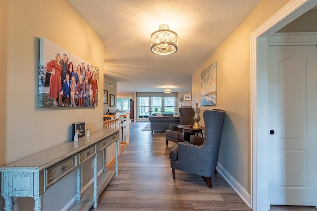 10641 Arrowwood Dr, Plain City, OH 43064 - corridor with wood finished floors, a textured ceiling, a chandelier, and baseboards