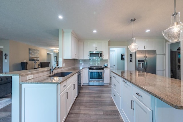 10641 Arrowwood Dr, Plain City, OH 43064 - kitchen featuring appliances with stainless steel finishes, a sink, white cabinets, tasteful backsplash, and light stone counters