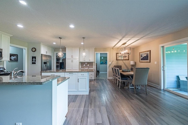 10641 Arrowwood Dr, Plain City, OH 43064 - kitchen featuring appliances with stainless steel finishes, dark wood-type flooring, white cabinetry, recessed lighting, and a kitchen island