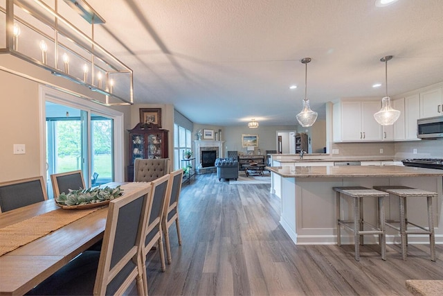 10641 Arrowwood Dr, Plain City, OH 43064 - kitchen featuring stainless steel appliances, wood finished floors, open floor plan, white cabinets, and recessed lighting