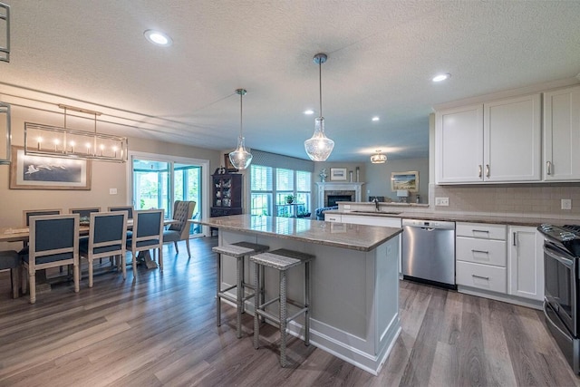 10641 Arrowwood Dr, Plain City, OH 43064 - kitchen with stainless steel dishwasher, dark wood-style floors, a sink, black range with electric stovetop, and a textured ceiling