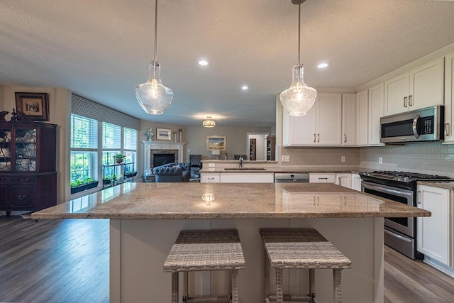 10641 Arrowwood Dr, Plain City, OH 43064 - kitchen with appliances with stainless steel finishes, a sink, dark wood-style flooring, white cabinets, and a textured ceiling