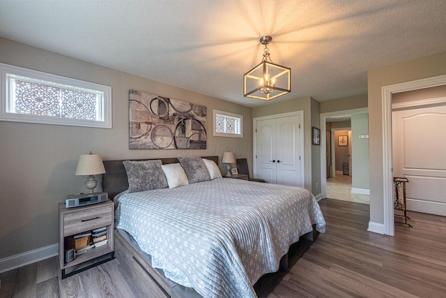 10641 Arrowwood Dr, Plain City, OH 43064 - bedroom with a chandelier, a closet, wood finished floors, baseboards, and a textured ceiling