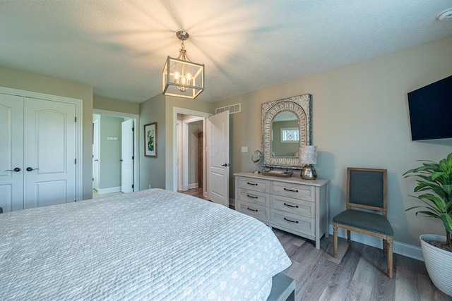 10641 Arrowwood Dr, Plain City, OH 43064 - bedroom featuring a chandelier, wood finished floors, baseboards, and a closet