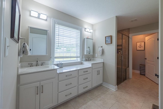10641 Arrowwood Dr, Plain City, OH 43064 - full bath with double vanity, a stall shower, tile patterned floors, a textured ceiling, and baseboards