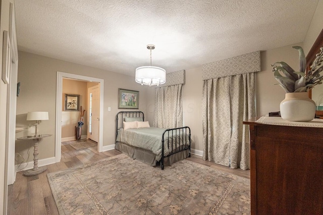 10641 Arrowwood Dr, Plain City, OH 43064 - bedroom featuring wood finished floors, a textured ceiling, and baseboards