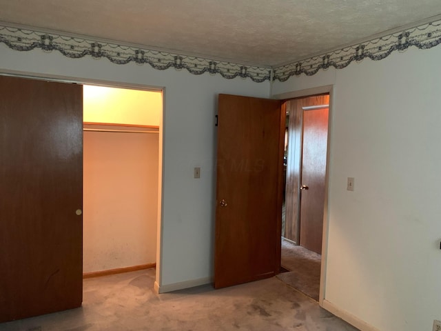 101 Gale Ct, Circleville, OH 43113 - unfurnished bedroom with carpet flooring, a spacious closet, a closet, baseboards, and a textured ceiling