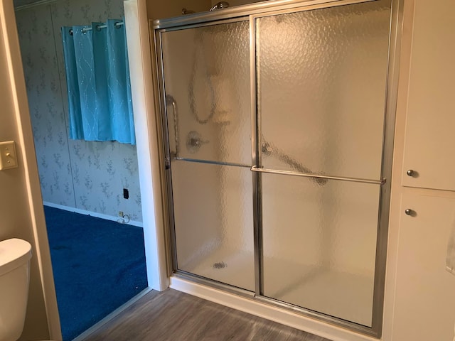 101 Gale Ct, Circleville, OH 43113 - bathroom featuring wallpapered walls, wood finished floors, toilet, and a shower with shower door